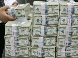 A bank employee counts one hundred dollar notes at a bank in Seoul