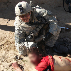 Солдат НАТО позирует возле убитого афганца